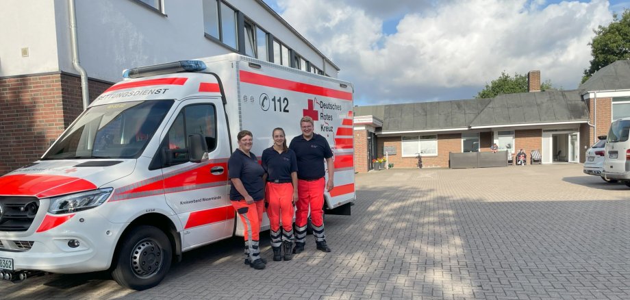 Bürgermeister Wärner und zwei Mitarbeiterinnen des Rettungsdienstes vor einem Rettungswagen