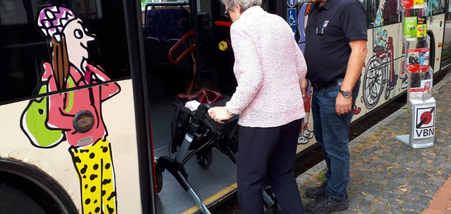 Seniorin steigt mit dem Rollator in einen Bus